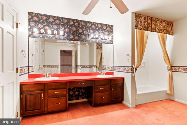 a spacious bathroom with a tub sink and mirror