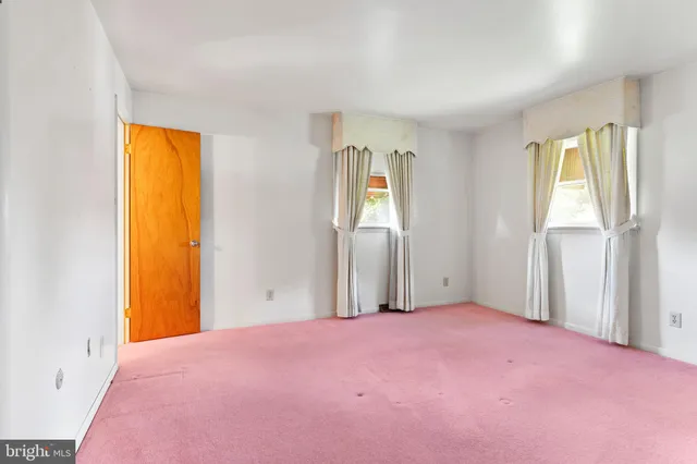 a view of empty room with windows and closet