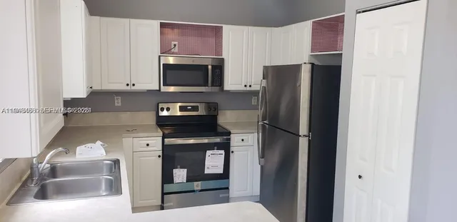 a kitchen with stainless steel appliances granite countertop a refrigerator and a sink