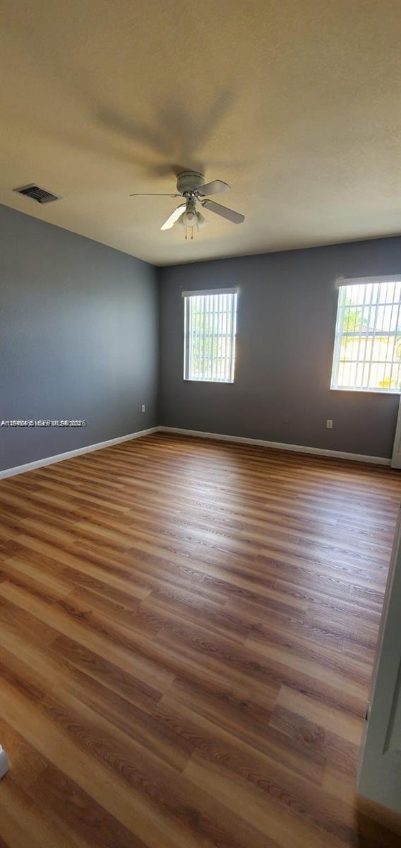 60 Southeast 6th Road, Unit 60 Homestead, FL 33030 - Photo 7 of 15 an empty room with wooden floor and windows