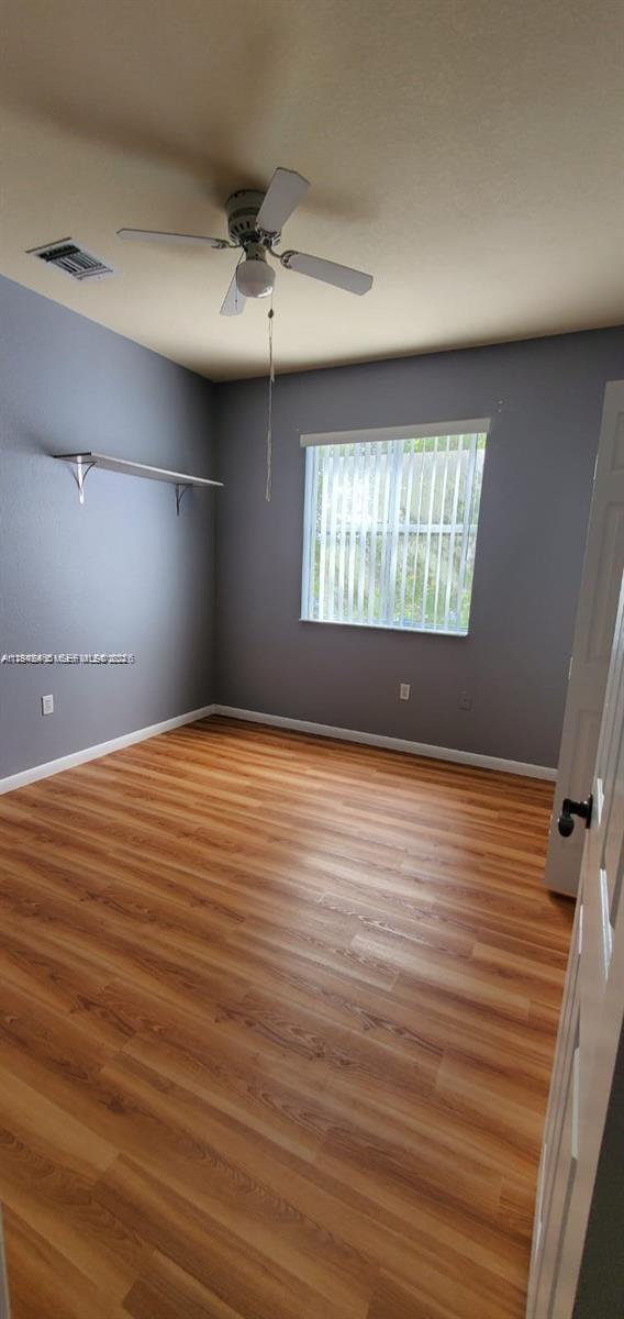 60 Southeast 6th Road, Unit 60 Homestead, FL 33030 - Photo 8 of 15 an empty room with wooden floor and windows