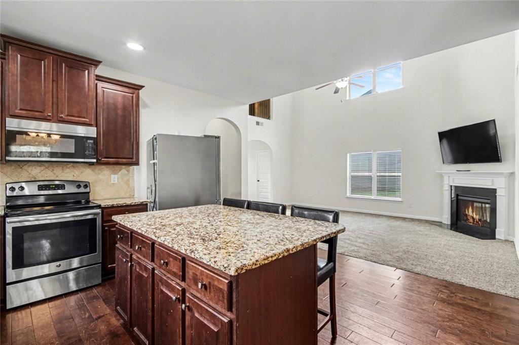 767 Effendi Place Fairburn, GA 30213 - Photo 11 of 35 a kitchen with granite countertop a sink stove and refrigerator