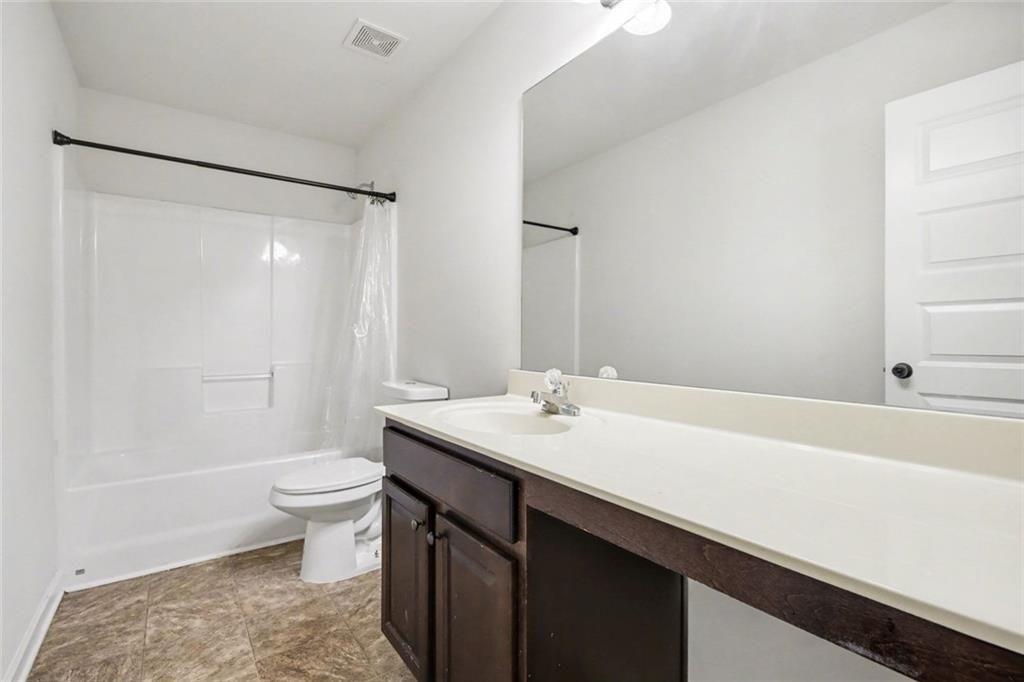 767 Effendi Place Fairburn, GA 30213 - Photo 25 of 35 a bathroom with a sink a toilet a mirror and shower