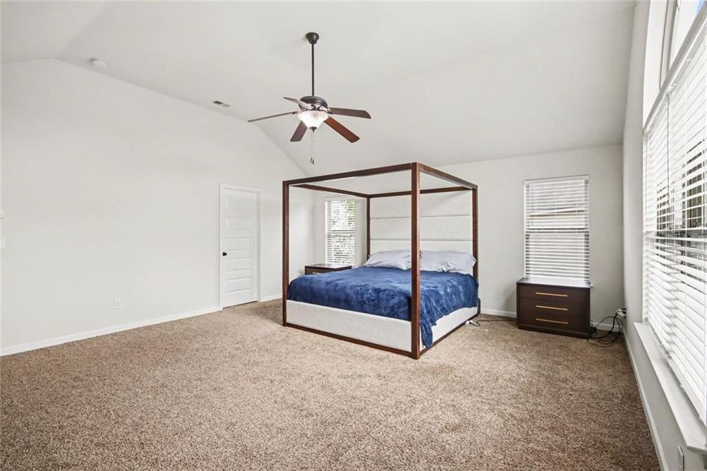 767 Effendi Place Fairburn, GA 30213 - Photo 28 of 35 a bedroom with a bed and a chandelier