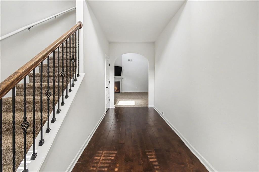 767 Effendi Place Fairburn, GA 30213 - Photo 3 of 35 a view of a hallway with wooden floor and staircase