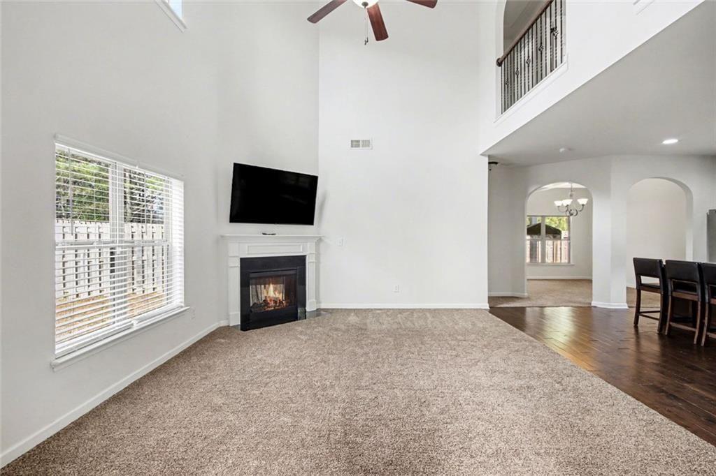 767 Effendi Place Fairburn, GA 30213 - Photo 6 of 35 a view of a livingroom with a fireplace a chandelier and wooden floor