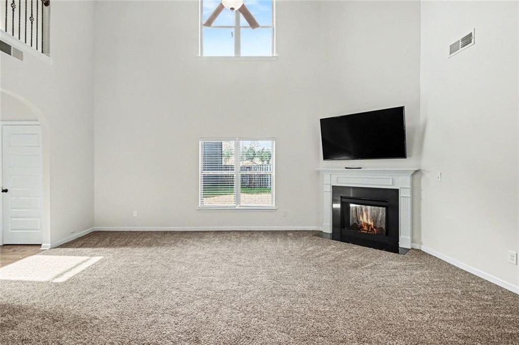 767 Effendi Place Fairburn, GA 30213 - Photo 9 of 35 a view of an empty room with a fireplace and a window