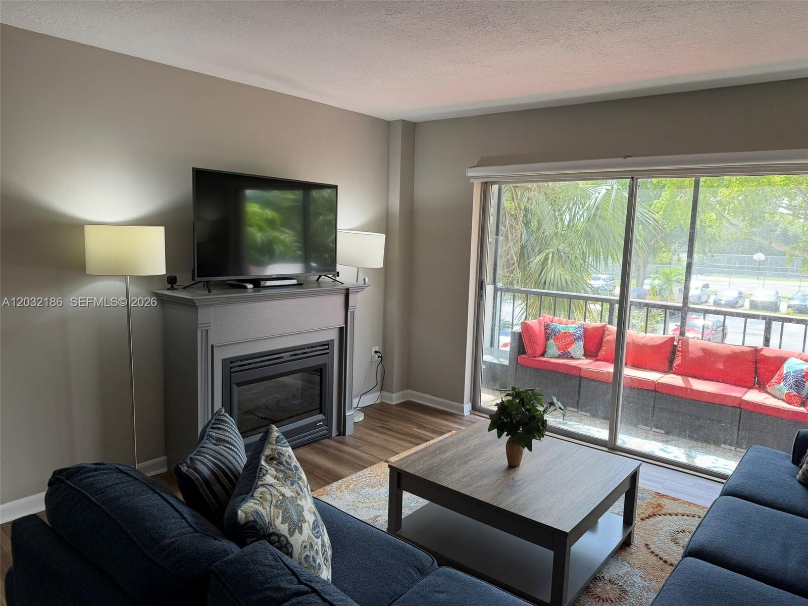4164 Inverrary Drive, Unit 204 Lauderhill, FL 33319 - Photo 6 of 28 a living room with furniture a flat screen tv and a fireplace