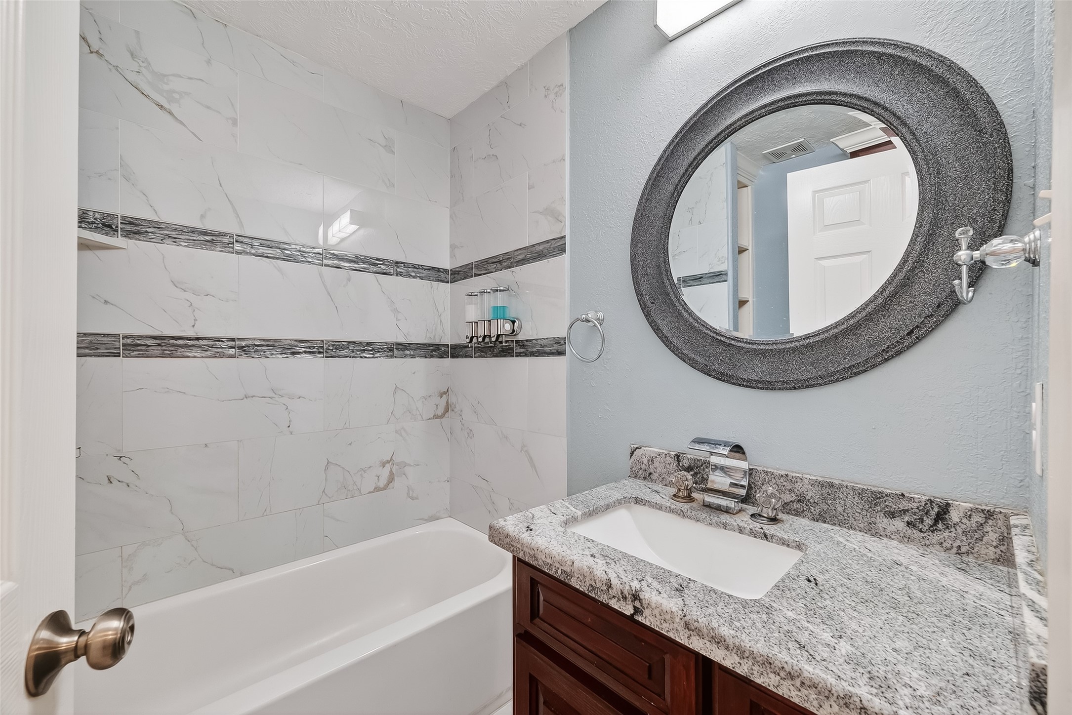 4901 Burning Tree Drive Baytown, TX 77521 - Photo 30 of 47 a bathroom with a granite countertop sink a mirror and a bathtub