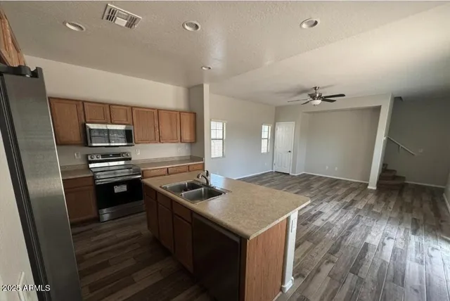 a kitchen that has a sink and stainless steel appliances
