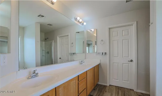 a bathroom with a double vanity sink and a mirror