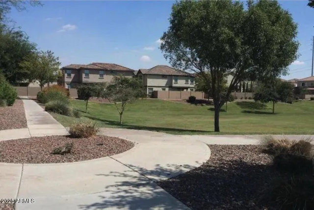 a front view of a house with a garden and lake view