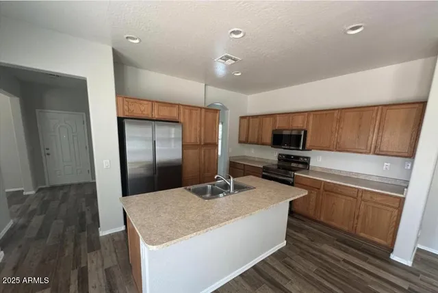 a kitchen with stainless steel appliances granite countertop a sink a stove and a refrigerator