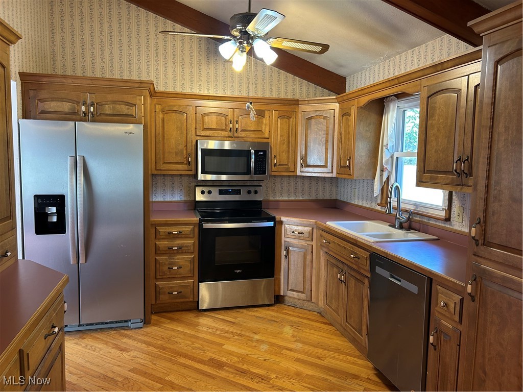 399 Abbyshire Road Green, OH 44319 - Photo 19 of 48 Kitchen view of appliances with stainless steel finishes, light wood floors, ceiling fan, and solid hardwood cabinetry, high vaulted ceiling with beams