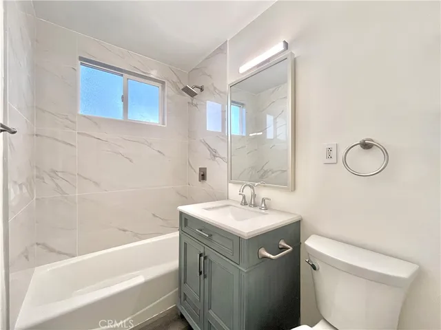 a bathroom with a sink toilet vanity and bathtub