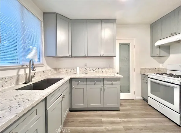 a kitchen with granite countertop a sink stainless steel appliances and cabinets