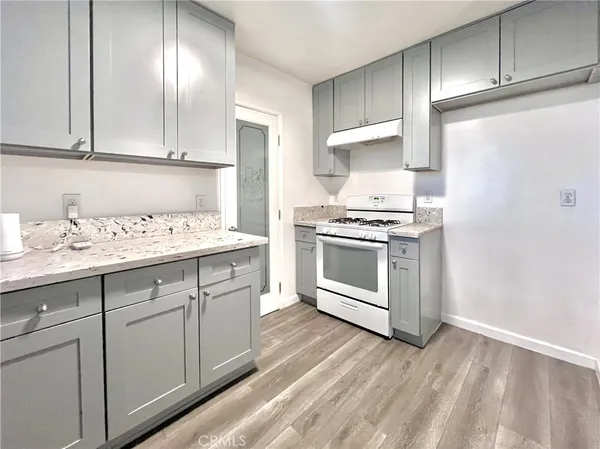 a kitchen with granite countertop white cabinets and white appliances