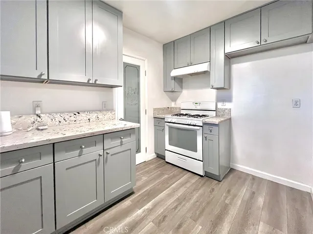 a kitchen with granite countertop white cabinets and white appliances