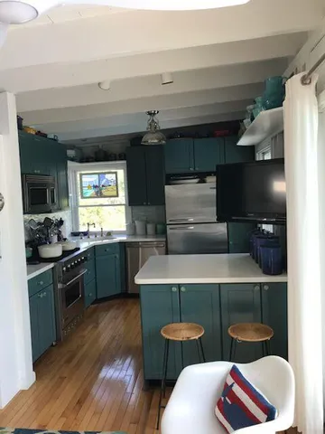 a kitchen with blue cabinets and black appliances