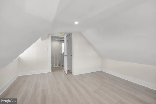 an empty room with wooden floor and white walls