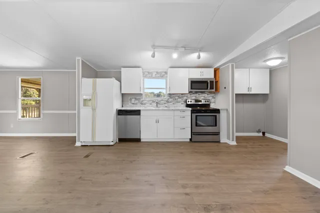 a kitchen with stainless steel appliances a stove sink and microwave