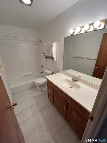 a living room with couches and kitchen view