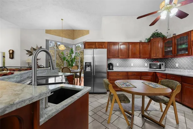 a kitchen with stainless steel appliances granite countertop a sink a stove and chairs