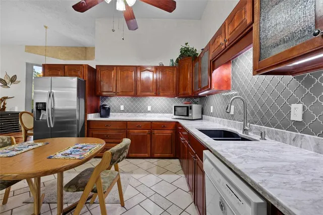 a kitchen with stainless steel appliances granite countertop a sink a stove and a refrigerator