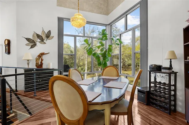 a view of a dining room with furniture a chandelier and wooden floor