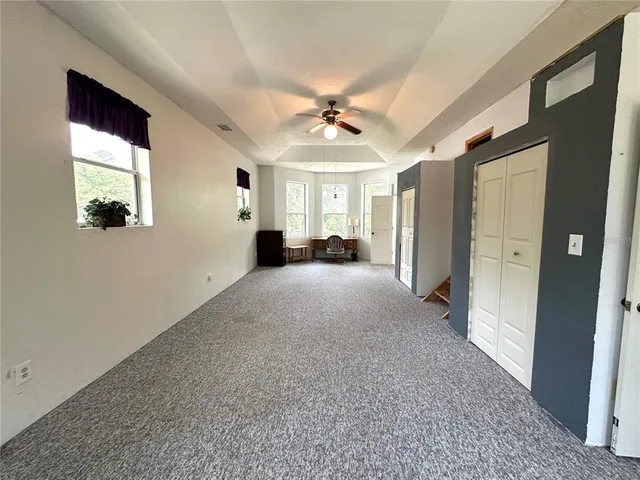 a view of a livingroom with a ceiling fan and window