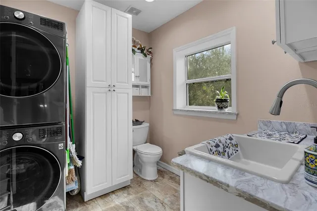 a bathroom with a granite countertop sink toilet and a mirror
