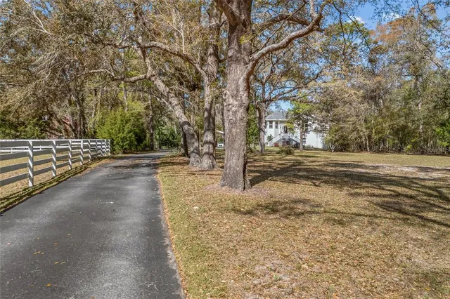 a view of a yard with wooden fence