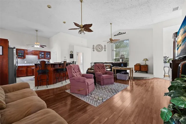 a living room with furniture kitchen view and a window