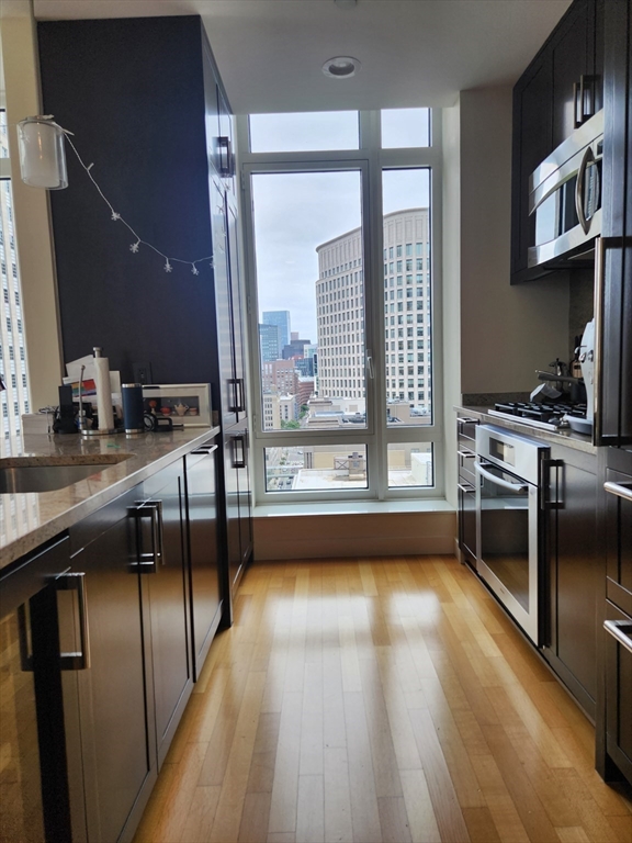 400 Stuart Street, Unit 18K Boston, MA 02116 - Photo 12 of 29 a kitchen with stainless steel appliances granite countertop a stove and a wooden floors
