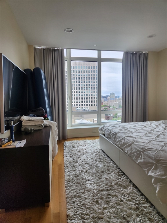400 Stuart Street, Unit 18K Boston, MA 02116 - Photo 18 of 29 a bedroom with a bed and a flat screen tv