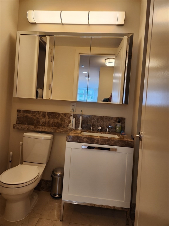 400 Stuart Street, Unit 18K Boston, MA 02116 - Photo 23 of 31 a bathroom with a toilet sink and mirror