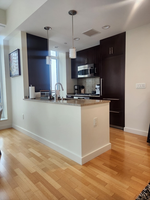 400 Stuart Street, Unit 18K Boston, MA 02116 - Photo 31 of 31 a kitchen with stainless steel appliances granite countertop a sink a stove top oven a counter space and cabinets