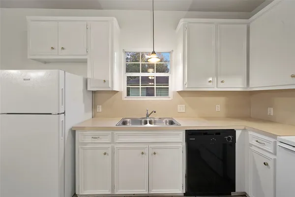 a kitchen with white cabinets and white appliances