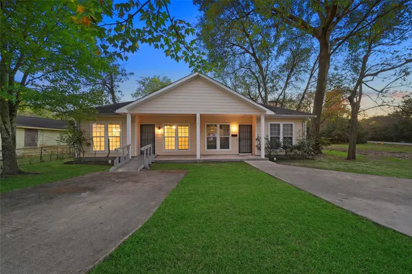 a front view of a house with yard and green space