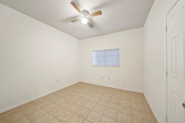 an empty room with a ceiling fan and a window