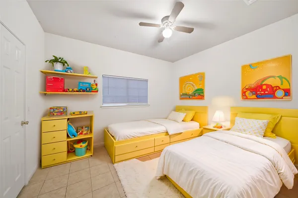 a bedroom with 2 bed and painting on the wall