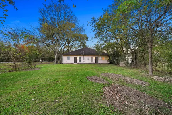 a view of a house with backyard and trees