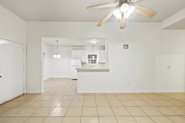 a view of kitchen and empty room with wooden floor