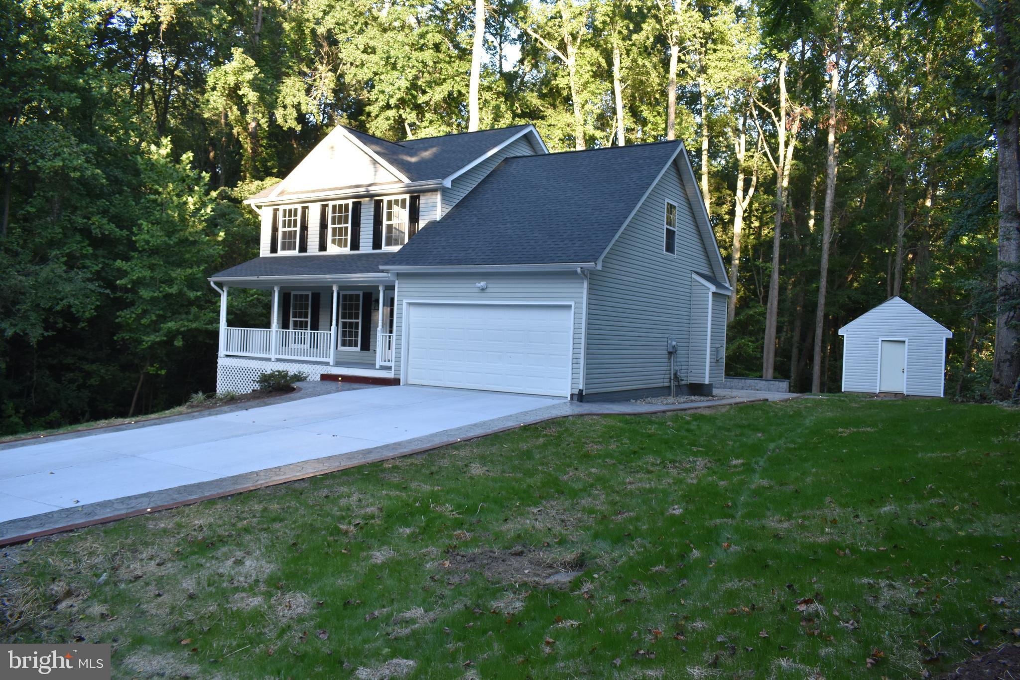 a view of a house with a yard and large tree