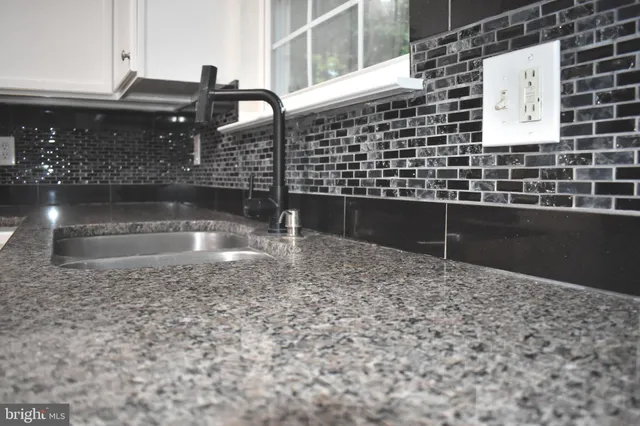 a view of an empty room with wooden floor fireplace and a window