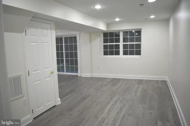 wooden floor in an empty room with wooden floor and a bathroom