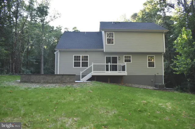 a view of a house with a yard and a large tree