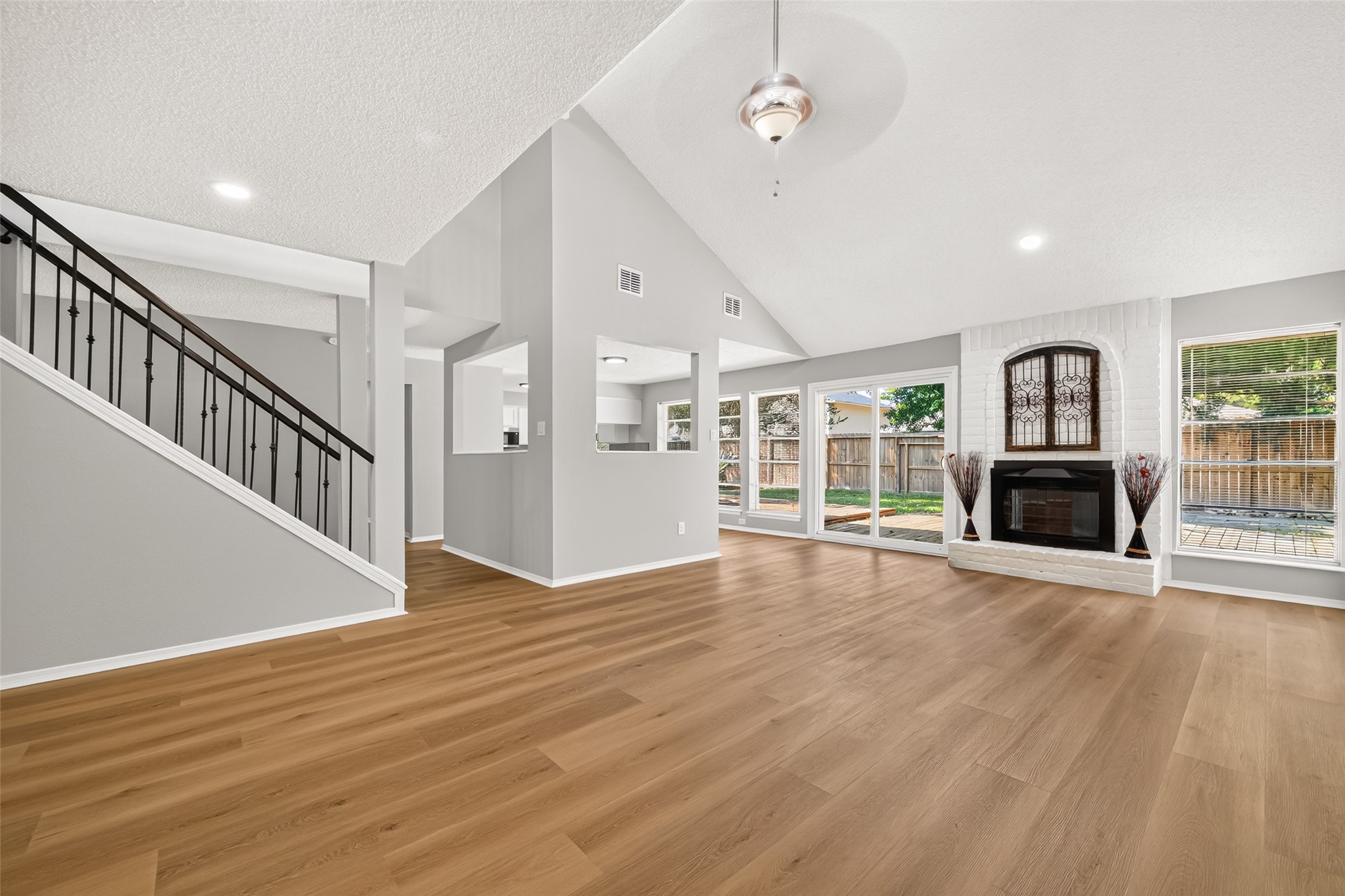 23219 Calico Corners Lane Spring, TX 77373 - Photo 9 of 24 Spacious living area with vaulted ceilings, a cozy fireplace, and large windows offering plenty of natural light and backyard views.