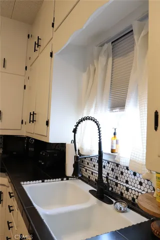 a bedroom with a bed and a lamp on dresser