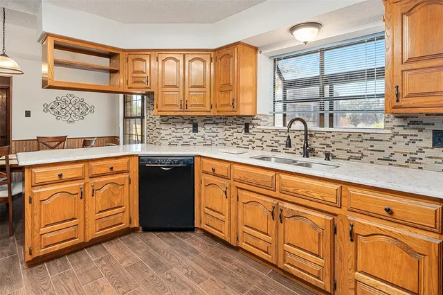 a kitchen with stainless steel appliances granite countertop a sink stove cabinets and wooden floor